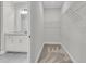 Spacious walk-in closet with custom shelving and carpet in neutral color scheme with access to the ensuite bath with quartz countertops at 3222 Pinewood Dr, Ladson, SC 29456