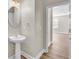 Bathroom features a pedestal sink, oval mirror, and doorway to a room with a window at 340 Albrighton Way, Moncks Corner, SC 29461