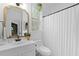 Bright bathroom featuring a plant near the window and shower with a white curtain at 3520 E Higgins Dr, Mount Pleasant, SC 29466
