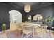 Stylish dining room boasts dark walls, a unique chandelier, and a view into the bright kitchen at 3520 E Higgins Dr, Mount Pleasant, SC 29466