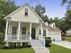 Charming home featuring a cozy front porch with a classic black door and attached two-car garage at 3520 E Higgins Dr, Mount Pleasant, SC 29466
