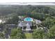Aerial view of a community pool with lounge chairs, mature trees, a clubhouse, and a parking lot at 3520 E Higgins Dr, Mount Pleasant, SC 29466