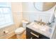 Modern bathroom with black vanity, marble countertop, gold fixtures, and white wainscoting at 3707 Gambrill Ln, Mount Pleasant, SC 29466