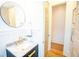 Modern bathroom with black vanity, marble countertop, gold fixtures, and round mirror at 3707 Gambrill Ln, Mount Pleasant, SC 29466
