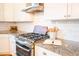 Close up of the gas range. Features include granite countertops, white tile backsplash, and stainless-steel appliances at 3707 Gambrill Ln, Mount Pleasant, SC 29466