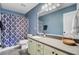 Well-lit bathroom with blue walls, a vanity with storage, a toilet, and a shower/bath with a patterned curtain at 407 Glenmore Dr, Moncks Corner, SC 29461