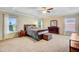 Spacious primary bedroom with tray ceilings, multiple windows, and dark wood furnishings, exuding comfort at 407 Glenmore Dr, Moncks Corner, SC 29461