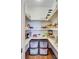 Well-organized pantry with white shelving, plastic drawers and hardwood flooring to maximize kitchen storage and efficiency at 407 Glenmore Dr, Moncks Corner, SC 29461
