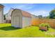 Exterior view of shed in the backyard with painted siding, red shingles, and secure double doors at 407 Glenmore Dr, Moncks Corner, SC 29461