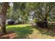 A backyard with lush green grass and mature trees, with a small fence and a pond in the distance at 4073 Blackmoor St, Mount Pleasant, SC 29466