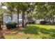 Backyard showing a large lush lawn, mature trees, a patio with an umbrella, and the exterior of the home at 4073 Blackmoor St, Mount Pleasant, SC 29466