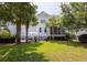 Backyard featuring a lush lawn, mature trees, a patio with a white umbrella, and a well-maintained lawn at 4073 Blackmoor St, Mount Pleasant, SC 29466