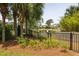 Scenic view of the backyard and pond beyond the fence with lush landscaping at 4073 Blackmoor St, Mount Pleasant, SC 29466