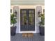 Stylish front door with glass panes, complemented by matching sconces and potted plants at 4073 Blackmoor St, Mount Pleasant, SC 29466