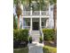 Elegant home entrance with a staircase to the porch, flanked by palm trees and lush greenery at 4073 Blackmoor St, Mount Pleasant, SC 29466