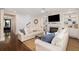 Spacious living room with hardwood floors, sectional sofa, fireplace, and adjacent dining area, creating a warm ambiance at 4073 Blackmoor St, Mount Pleasant, SC 29466