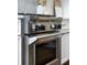 Close-up of stainless steel oven with black knobs, complementing the white cabinets and herringbone tile backsplash at 4073 Blackmoor St, Mount Pleasant, SC 29466