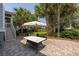 Inviting outdoor patio with brick pavers, umbrella covered table, and lush tropical landscaping create a relaxing atmosphere at 4073 Blackmoor St, Mount Pleasant, SC 29466