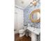 Charming powder room with floral wallpaper, pedestal sink, and stylish mirror, a perfect blend of elegance and comfort at 4073 Blackmoor St, Mount Pleasant, SC 29466