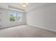 Bright bedroom featuring a tray ceiling, large window, neutral carpet, and stylish decorative wall trim at 5133 Park Creek Ave, North Charleston, SC 29418