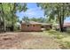 Spacious backyard featuring a well-kept lawn and mature trees for shade at 5172 Sterrett St, North Charleston, SC 29405