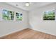 Empty bedroom with hardwood floors, neutral paint, and bright natural light from dual windows at 5172 Sterrett St, North Charleston, SC 29405