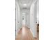 Hallway with hardwood floors, white walls, and multiple doorways to other rooms at 5172 Sterrett St, North Charleston, SC 29405