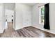 This bedroom features a window, luxury vinyl flooring, and white walls at 5233 Maybank Hwy, Wadmalaw Island, SC 29487