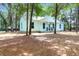 Charming exterior of the home, surrounded by trees, and a cozy front porch at 5233 Maybank Hwy, Wadmalaw Island, SC 29487