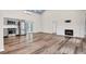 Bright open-concept living space with hardwood floors, stainless appliances, and a cozy fireplace at 5233 Maybank Hwy, Wadmalaw Island, SC 29487
