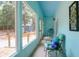 A light blue screened in porch features a seating area with views of the yard at 5233 Maybank Hwy, Wadmalaw Island, SC 29487