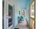 A light blue screened in porch includes a doorway and seating area at 5233 Maybank Hwy, Wadmalaw Island, SC 29487