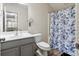 Bright bathroom featuring neutral walls, wood look floor, blue leaf shower curtain, and gray vanity at 535 Crossland Dr, Moncks Corner, SC 29461