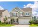 Two-story home showcasing a well-manicured lawn, gray siding, and a two-car garage on a sunny day at 535 Crossland Dr, Moncks Corner, SC 29461