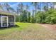 Expansive backyard featuring green grass and mature trees, complemented by a screened porch, ideal for outdoor enjoyment at 5725 Caviar Ct, Johns Island, SC 29455