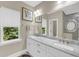 Bathroom featuring a double sink vanity, large mirror, and view into the marble-look shower at 5725 Caviar Ct, Johns Island, SC 29455