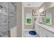 Bright bathroom with a double sink vanity, large mirror, and walk-in shower with marble-look tile at 5725 Caviar Ct, Johns Island, SC 29455