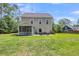 Rear view of the home highlighting the spacious backyard, screened porch, and patio, great for outdoor enjoyment at 5725 Caviar Ct, Johns Island, SC 29455