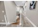 A carpeted hallway with an artful staircase and neutral walls leads to other rooms in the house at 5725 Caviar Ct, Johns Island, SC 29455