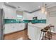 Modern kitchen featuring white cabinetry, a breakfast bar, and unique green backsplash, perfect for entertaining at 5725 Caviar Ct, Johns Island, SC 29455