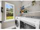 Bright laundry room with high efficiency washer and dryer, convenient shelving, and large window view at 5725 Caviar Ct, Johns Island, SC 29455