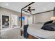 An interior shot of a main bedroom with dark wood bed frame, ceiling fan, and ensuite bathroom at 5725 Caviar Ct, Johns Island, SC 29455