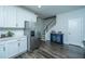Modern kitchen boasts white cabinets, stainless steel fridge, and a stylish blue cabinet with wine rack near the stairs at 618 Ravensridge Ln, Moncks Corner, SC 29461