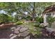 Scenic backyard featuring a stone pathway, lush landscaping, and views of the charming cottage and main house at 708 Pitt St, Mount Pleasant, SC 29464