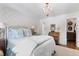 Bright bedroom featuring a chandelier, wallpaper, and a comfortable bed with soft lighting at 708 Pitt St, Mount Pleasant, SC 29464