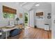 Bright interior of the outbuilding featuring wood floors, white walls, and natural light from two windows at 708 Pitt St, Mount Pleasant, SC 29464