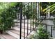 Close-up of the wood staircase, showcasing the black iron railing and lush greenery at 708 Pitt St, Mount Pleasant, SC 29464