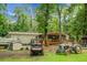 A rustic scene of backyard living showcases a variety of vehicles and equipment amidst lush greenery at 785 Coral Acres Dr, Moncks Corner, SC 29461