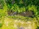 A beautiful aerial view of a dark pond surrounded by lush green grass and trees at 8453 Charleston Hwy, Walterboro, SC 29488