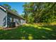 Lush backyard featuring mature trees, manicured lawn, and light blue home with windows at 8453 Charleston Hwy, Walterboro, SC 29488